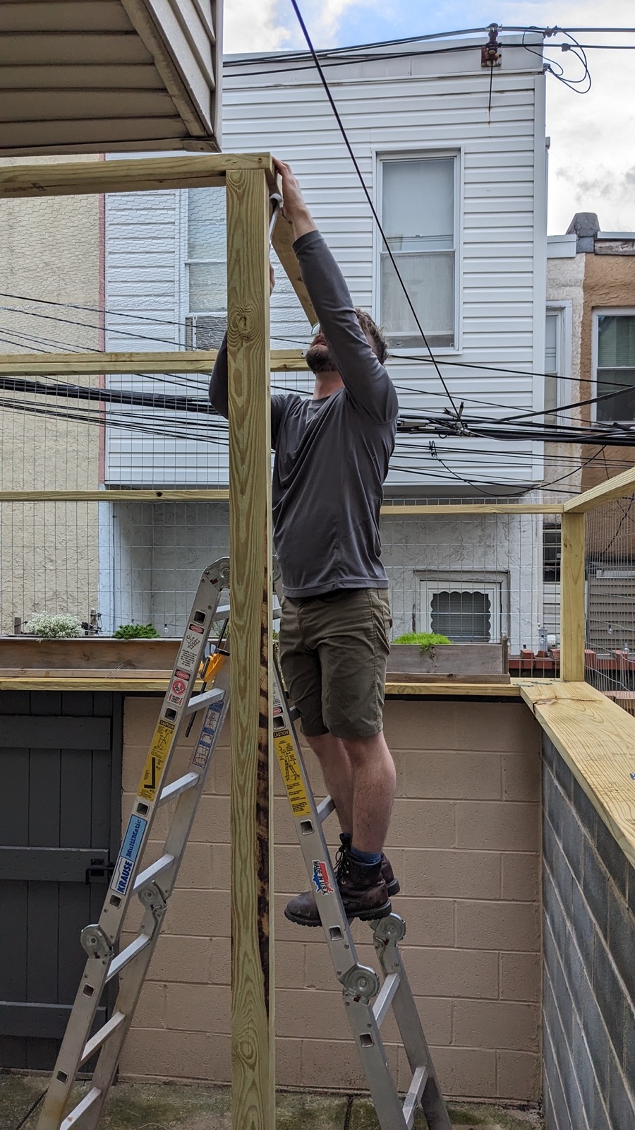 Man hammering the frame of a catio enclosure